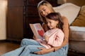 Happy daughter greeting mom with card, reading together Royalty Free Stock Photo