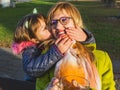 Happy daughter kissing her mother in a sunlight. Fun healthy family life in a winter Royalty Free Stock Photo