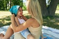 Happy daughter playing with her mother in sunny summer day in the park. Joyful kid and young woman having cozy picnic outdoors. Royalty Free Stock Photo