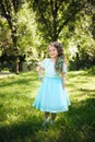 Happy daughter smiling at camera in summer park