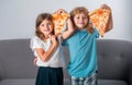 Happy daughter and son eating pizza. Children kids enjoy and having fun with lunch together at home. Funny children Royalty Free Stock Photo