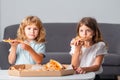 Happy daughter and son eating pizza. Children kids enjoy and having fun with lunch together at home. Little friends, boy Royalty Free Stock Photo