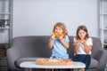 Happy daughter and son eating pizza. Children kids enjoy and having fun with lunch together at home. Two young children Royalty Free Stock Photo