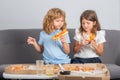 Happy daughter and son eating pizza. Children kids, little girl and boy eat pizza. Royalty Free Stock Photo