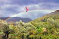 Happy day. Sailboat sails along the rainbow between mountains. Travel, dream, fantasy concept