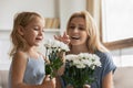 Delighted elder and younger sisters receiving flowers on March 8 Royalty Free Stock Photo