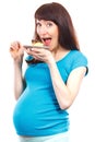 Happy delighted pregnant woman eating cheesecake, concept of nutrition during pregnancy