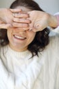 Happy delighted woman in knitted sweater closing her eyes with hands palms out and smiling on camera Royalty Free Stock Photo