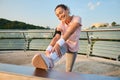 Happy, delighted young African American sportswoman stretching her legs while working out outdoor Royalty Free Stock Photo