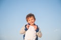 Happy delightful laughing little child in sweater on blue sky background Royalty Free Stock Photo
