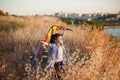 Happy delightful smiling small kid with kite in hands standing on summer field nea sea port outside city with closed