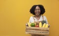 Happy delivery from African American woman carrying cart full of tropical organic homegrown produce from local garden for vegan Royalty Free Stock Photo