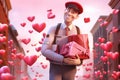 Happy delivery man with gift boxes in the city. Valentine\'s day concept, of a handsome man delivering valentines,
