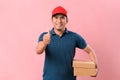 Happy delivery man standing holding parcel box showing thumb up Royalty Free Stock Photo