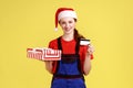 Happy delivery woman holding wrapped present box and showing credit card, bonus for deliver order. Royalty Free Stock Photo