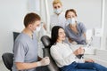 Happy dentist patient checking whitening results looking in a mirror. Young dentists in dental office talking with female patient Royalty Free Stock Photo