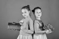 Happy dessert concept. Sisters with lollipops, boxes and bags. Children eat colorful caramels Royalty Free Stock Photo
