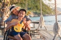 Happy disability kid concept at the beach with ukulele