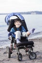 Happy disabled boy in wheelchair on the beach