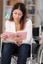 happy disabled handicapped woman sit on wheelchair holding book Royalty Free Stock Photo