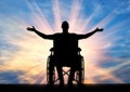 Happy disabled man in a wheelchair with arms raised up