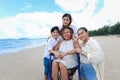 Happy disabled senior elderly woman in wheelchair spending time together with her family on tropical beach. Asian grandma,