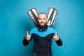 Happy diver with fins showing thumb up gesture on blue background Royalty Free Stock Photo