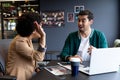 Happy diverse businessman and businesswoman high fiving in creative office