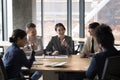 Happy diverse businesspeople laugh, brainstorm, discuss business ideas in office Royalty Free Stock Photo