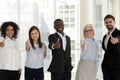 Happy diverse businesspeople standing looking at camera showing thumbs up Royalty Free Stock Photo