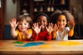 Happy diverse children raising painted hands kindergarten child kids playing playful joyful enjoying colorful paint Royalty Free Stock Photo