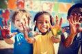 Happy diverse children raising painted hands kindergarten child kids playing playful joyful enjoying colorful paint Royalty Free Stock Photo