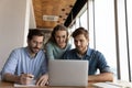 Happy diverse colleagues brainstorm using laptop in office Royalty Free Stock Photo