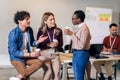 Diverse colleagues have fun at lunch break in office, smiling multiracial employees laugh and talk drinking coffee Royalty Free Stock Photo