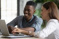 Happy diverse colleagues working on project together, using laptop Royalty Free Stock Photo