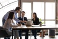 Happy diverse colleagues working on project together, using laptop Royalty Free Stock Photo