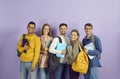 Happy diverse college or university students with bags, laptops and books standing in studio Royalty Free Stock Photo