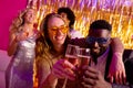 Happy diverse couple dancing and toasting with champagne at a nightclub Royalty Free Stock Photo