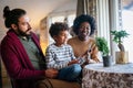 Happy diverse couple, parent with her child taking care of plants indoors. Family love concept. Royalty Free Stock Photo