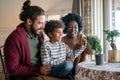 Happy diverse couple, parent with her children taking care of plants indoors. Family love concept. Royalty Free Stock Photo