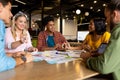 Happy diverse creative colleagues in discussion brainstorming using tablet and notes in office Royalty Free Stock Photo