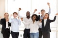 Happy diverse employees celebrating victory and success at work Royalty Free Stock Photo