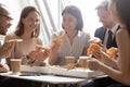 Happy diverse employees enjoying pizza, having fun during break together