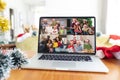 Happy diverse families smiling on laptop group video call screen at christmas time