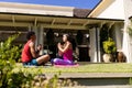 Happy diverse fit couple practicing yoga meditation sitting in sunny garden, with copy space Royalty Free Stock Photo