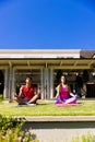 Happy diverse fit couple practicing yoga meditation sitting in sunny garden, with copy space Royalty Free Stock Photo