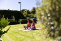 Happy diverse fit couple practicing yoga meditation sitting in sunny garden, with copy space Royalty Free Stock Photo