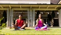 Happy diverse fit couple practicing yoga meditation sitting in sunny garden Royalty Free Stock Photo