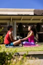 Happy diverse fit couple practicing yoga sitting in sunny garden, with copy space Royalty Free Stock Photo