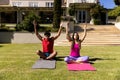 Happy diverse fit couple practicing yoga sitting in sunny garden Royalty Free Stock Photo